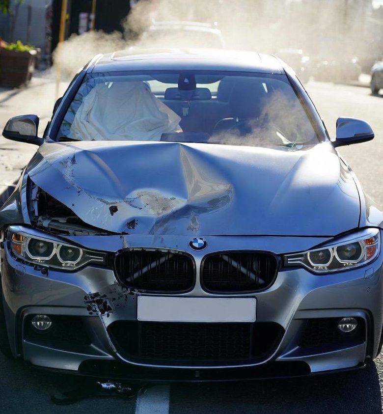 BMW Unfallfahrzeug mit Frontschaden und beschädigter Motorhaube auf der Straße