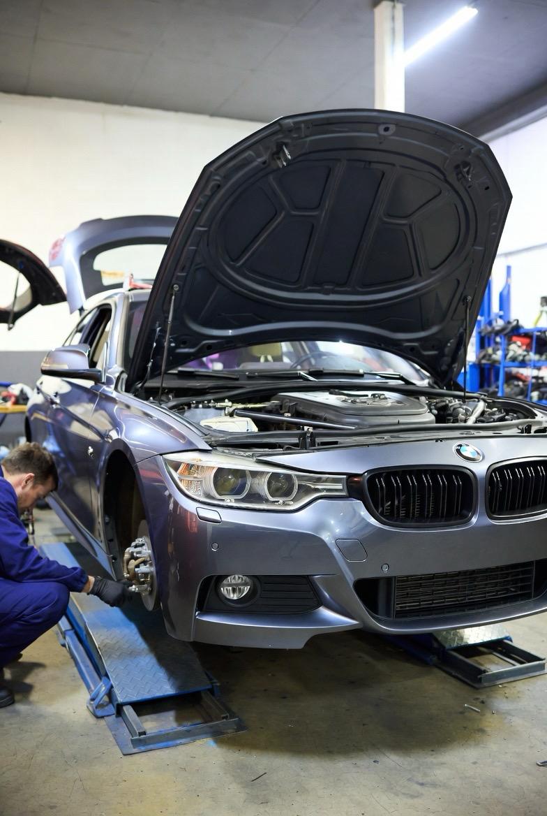 BMW Fahrzeug auf Hebebühne bei Inspektion und Wartungsarbeiten in Werkstatt